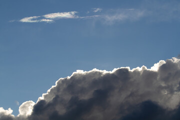 Dark cumulus clouds. Blue sky. Natural background.