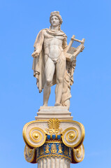 Apollo statue with golden decorations against blue sky