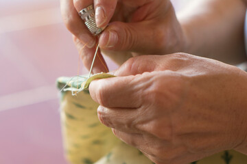 MUJER CON DEDAL Y AGUJA COSIENDO