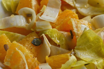 Chicoree Orange Salat mit Kürbis- und Sonnenblumenkerne sehr nah fotografiert, flächendeckend. 