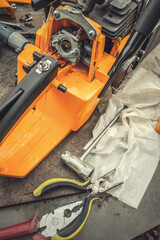 Repair chainsaws at home, parts and pliers on the table.