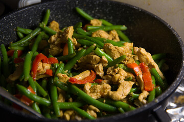 Sprinkling fresh coriander over a delicious chicken tikka masala with Indian spices
