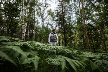 young woman deep in siberian forest with fern around