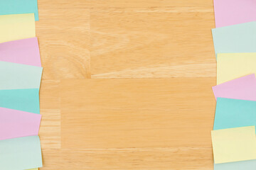 Sticky note background with multi-color notes on a wood desk