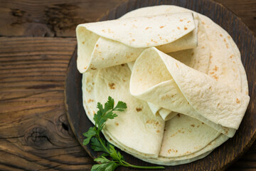 Whole wheat flour tortilla on the wooden table background 
