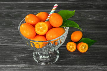 ripe kumquat fruit in a glass bowl on the table close-up. background with fresh kumquat fruits.