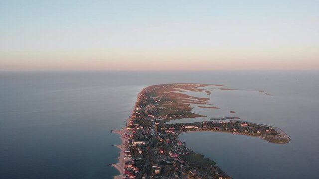 Aerial drone footage Seaside resort by the sea. Beautiful sandy beach on Berdyansk sea spit, Sea of ​​Azov. Buildings are located along the entire length of the sea coast