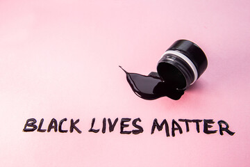 Overturned can of black paint, paint spilled from the can with note. Black Lives Matter. Equal...