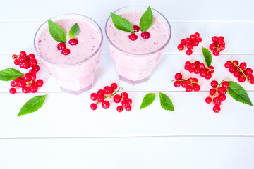 berry milkshake and red currant berries on a white background close-up. cocktail of red currant berries in glasses on the table. background with milkshake and red currant berries.