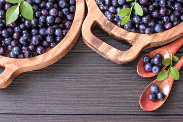 ripe fresh blueberries in wooden bowls and spoons close-up. blueberries in macro bowls. background with berries blueberries.
