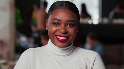 Portrait of happy young beautiful 20s gen-z black business woman with red lips smiling at camera at...