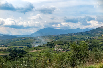 Valley with several farms and plantations and mountains in the background, Campania region, Benevento province, Italy