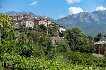 Fototapeta na wymiar Small medieval Italian town on top of a hill, with high mountains in the background, commune of Pratella, Campania region, province of Caserta, Italy