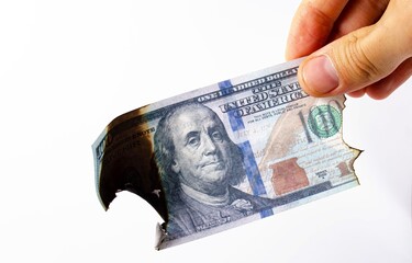 American dollars in a man's hand on a white background first-person view. Burnt dollars. Dollars are burning, Ashes, fire