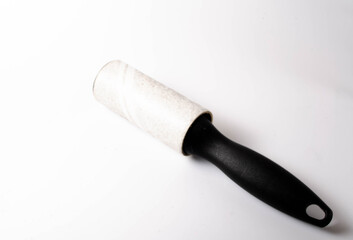 Roller for cleaning clothes on a white background in close-up. A flexible roller for cleaning clothes in a man's hand. Used, dirty clothes roller