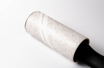 Roller for cleaning clothes on a white background in close-up. A flexible roller for cleaning clothes in a man's hand. Used, dirty clothes roller