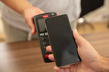 POS terminal for payment with smartphone, nfc technology. Cashier and customer hands