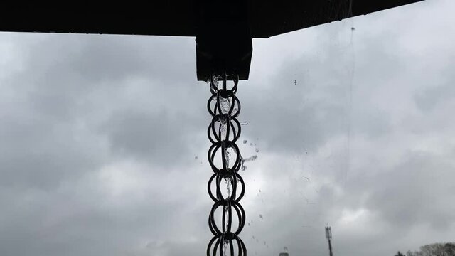 台風の日に暴風雨に晒される鎖樋(くさりどい)。流れる大量の雨水