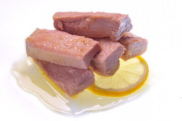 Tuna fillets in oil on lemon slice on white background
