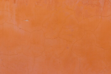 The wall is orange. Small cracks on the surface. Texture and background. Old wall.