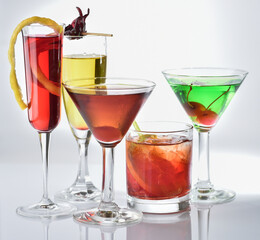 five different glasses of colorful cocktails on a white background