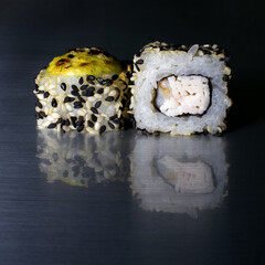 Japanese rolls with fish and crab meat reflection, with rice, sesame seeds, white sauce and seaweed