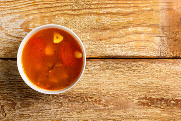 Traditional Thai Tom Yam soup in a plate on a wooden table. Copy space.