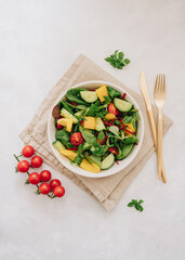 Vegetable salad with olive oil in white bowl on linen napkin