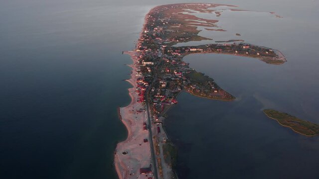 Aerial drone footage Seaside resort by the sea. Beautiful sandy beach on Berdyansk sea spit, Sea of ​​Azov. Buildings are located along the entire length of the sea coast