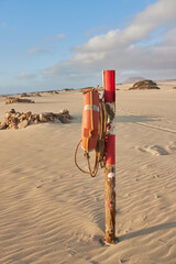 Red marine rescue buoy on a Fuerteventura beach, in a sunny morning with very fine white sand