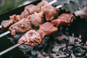 Cooking barbecue skewers. Marinated kebab is grilled on charcoal. Pork Shish kebab cooking outdoor. Close-up 