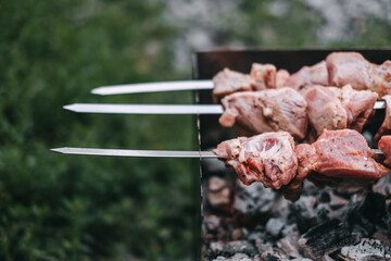 Cooking barbecue skewers. Marinated kebab is grilled on charcoal. Pork Shish kebab cooking outdoor. Close-up 