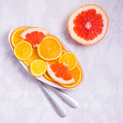 Citrus slices of orange, grapefruit, lemon on plate. Vitamin C concept. White background