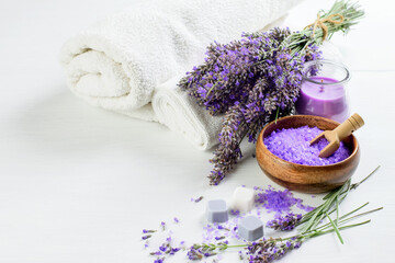 Obraz na płótnie Canvas Lavender flowers and lavender salt, soap, candle and white towels for spa aroma therapy.