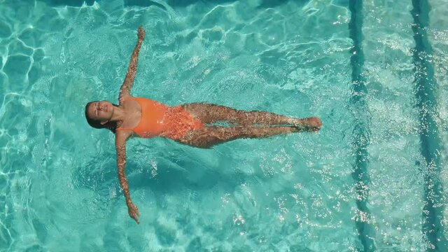 woman is floating on back in pool