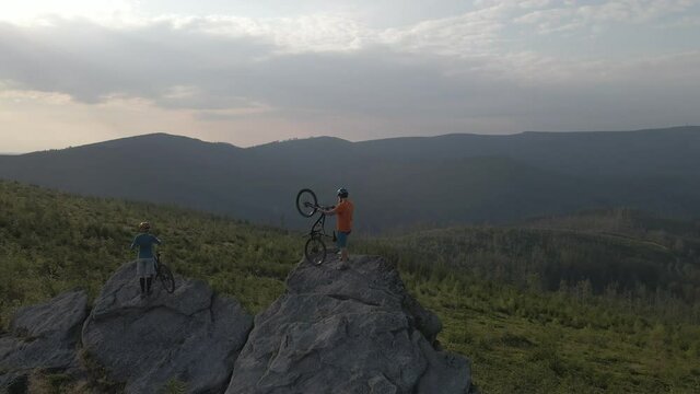Aerial shot of mountainbike couple cycling in summer mountains landscape. Man and woman on MTB trail outdoor adventure.