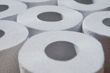 Rolls of toilet white paper stand on top of each other.