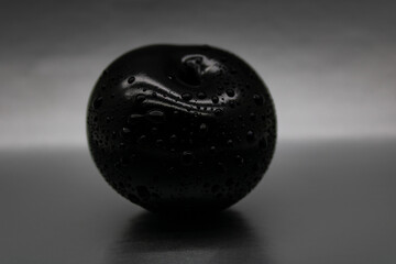 Black plum berry in water drops
