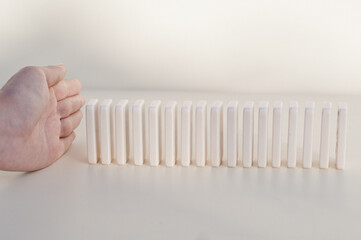 Close-up Of Businesswoman Stopping The Effect Of Domino With Hand At Desk