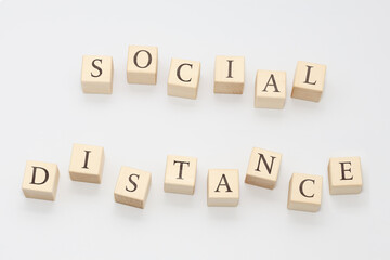 The phrase social distance is lined with cubes on a light gray background.