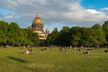  Lawn on Senate Square with people resting in front of St. Isaac's Cathedral. Saint Petersburg,...