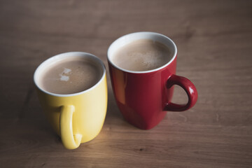 Two cups of cappuccino with latte art on wooden background