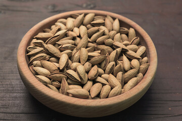 Almonds in shells in a wooden plate