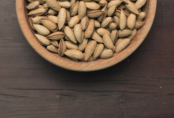 Almonds in shells in a wooden plate