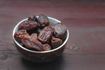 Dates, dried fruits in a plate on a wooden table