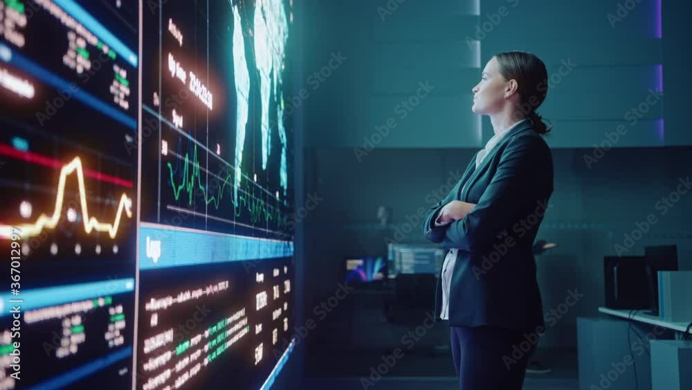 Poster Young Female Computer Science Engineer Looking at Big Screen Display Showing Global Map with Data Points. Telecommunications Technology Company System Control and Monitoring Room with Servers.