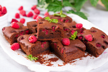 Brownie pieces with raspberries on gray background decorated with berries