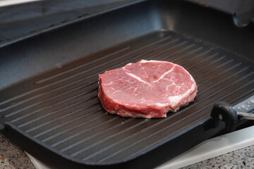 Raw aged Angus steak, fried in a cast-iron pan. Fluted frying pan.