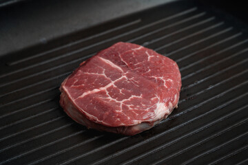 Raw aged Angus steak, fried in a cast-iron pan. Fluted frying pan.