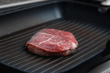 Raw aged Angus steak, fried in a cast-iron pan. Fluted frying pan.
